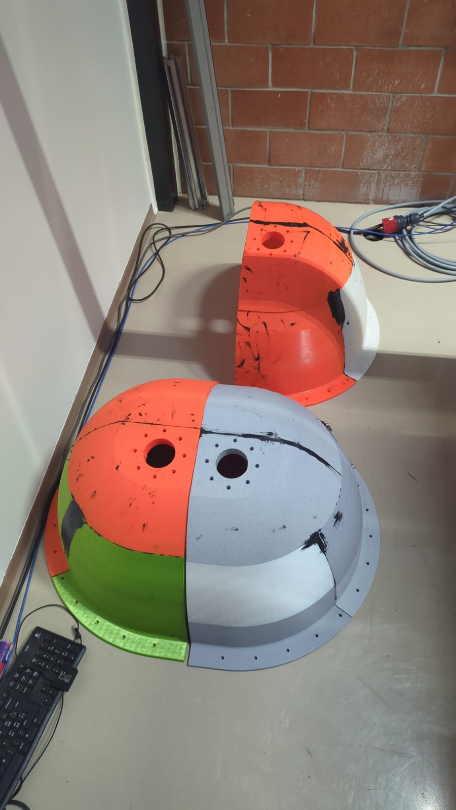 Two 3D-printed PETG eggshell cores on a bench, printed in segments and bonded together, one cut open