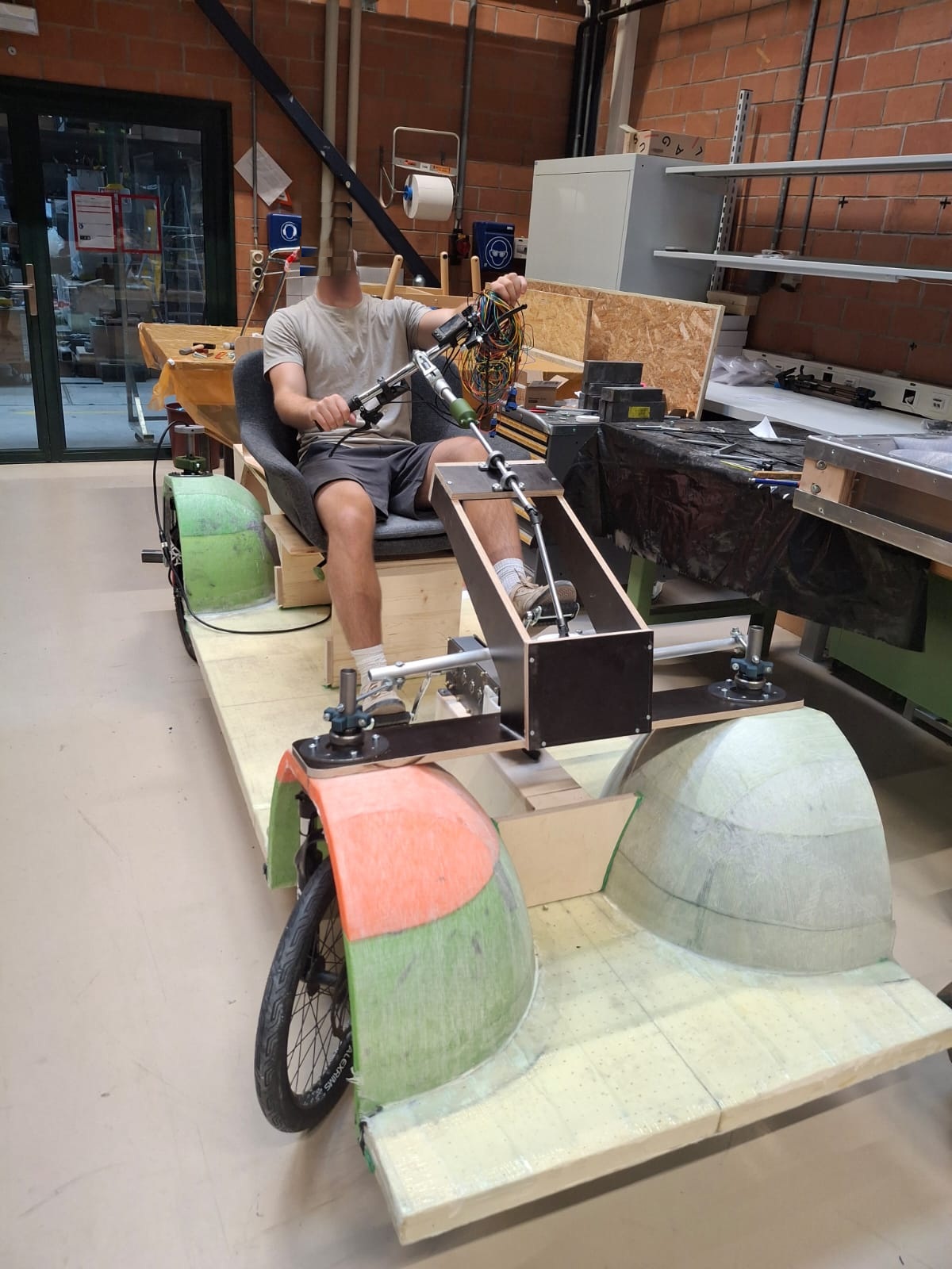 SUV1 complete, with a rider seated at the handlebar in the workshop